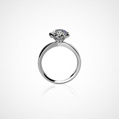 © Juwelier Wagner-Madler e.K. Ein silberner Verlobungsring mit einem einzelnen runden Diamanten an der Oberseite ist vor einem schlichten weißen Hintergrund zu sehen. Der Diamant, der von vier Zinken gehalten wird, funkelt brillant auf dem schlanken und schlichten Ringdesign und ist somit ein perfekter Eintrag in jedes Schmucklexikon.